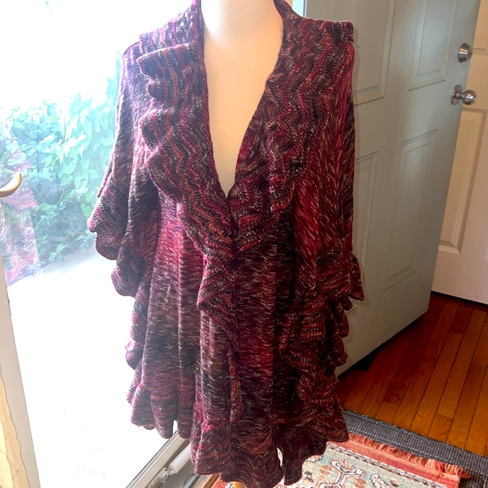 It’s a pretty ruffle cardigan open from the front. Mix of red purple white